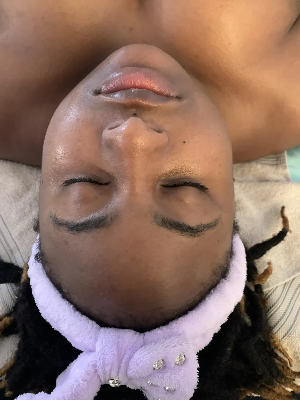 A guest reclining on a facial treatment bed
